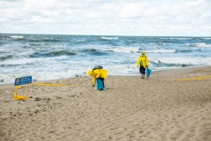 Savanoriai tvarko audringą Melnragės pajūrį