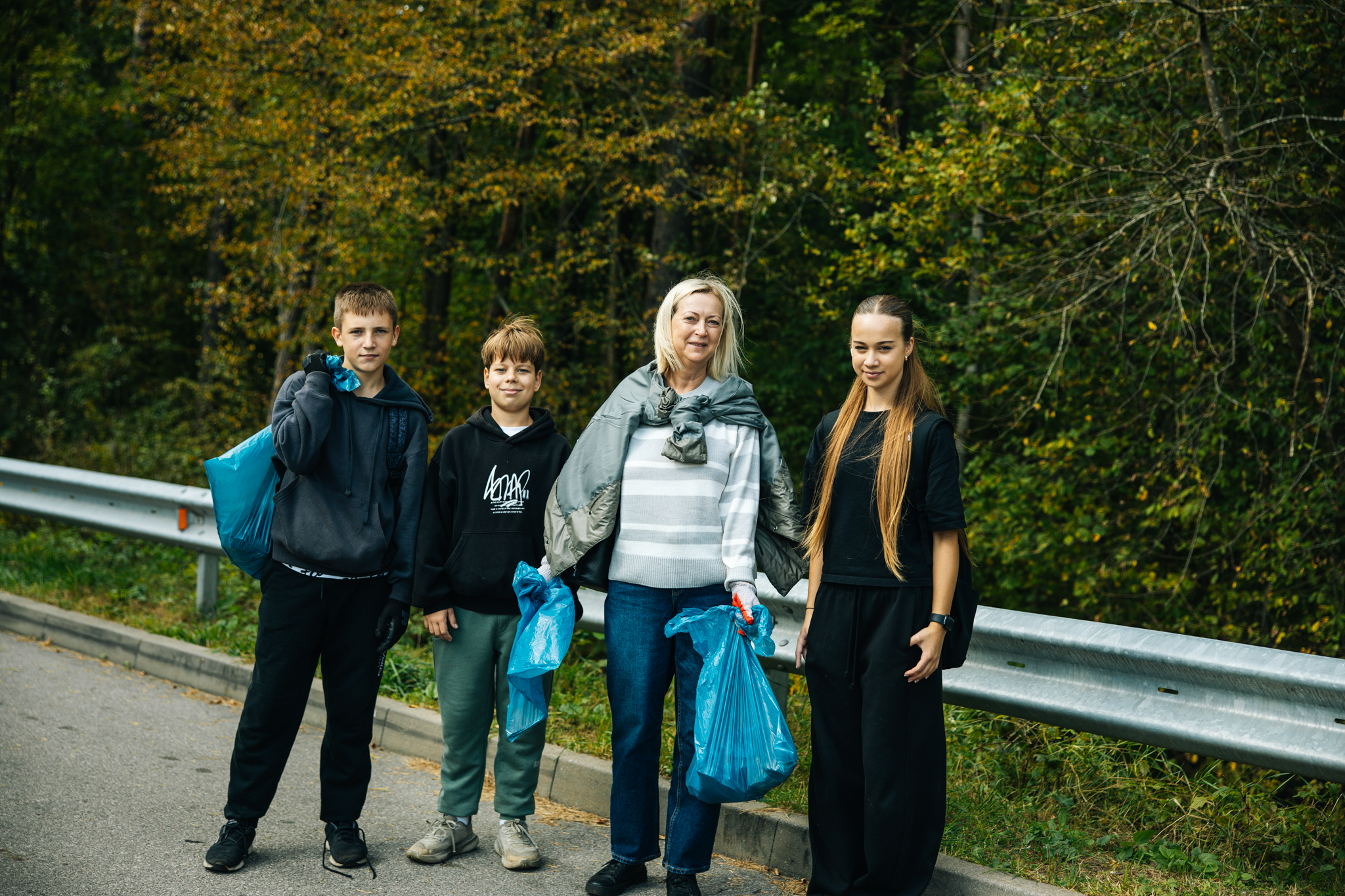 Šeima su surinktų atliekų maišais tvarkymosi akcijoje