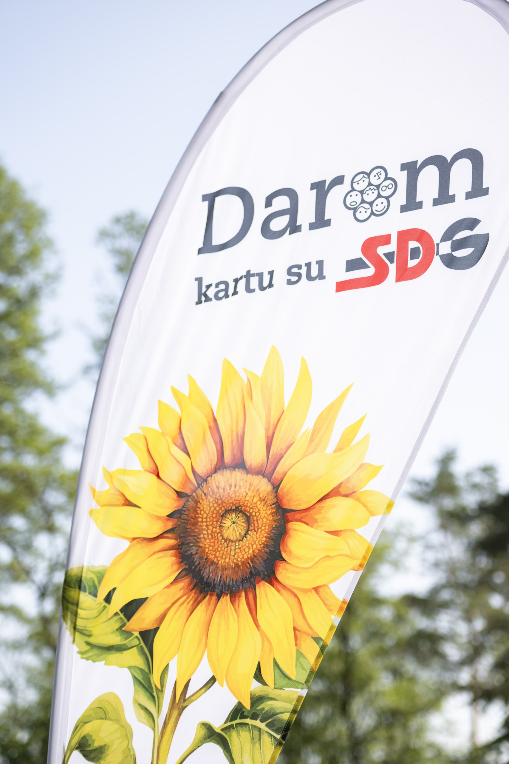 „Darom kartu su SDG“ vėliava su saulėgrąža